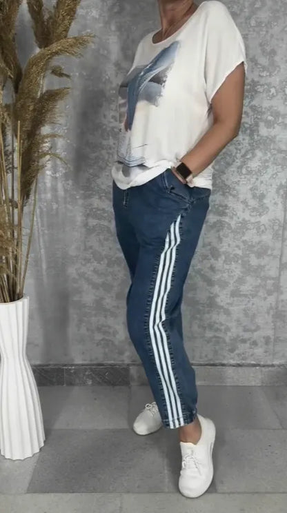 T-shirt with a round neckline batwing sleeves jeans with three stripes on the sides set